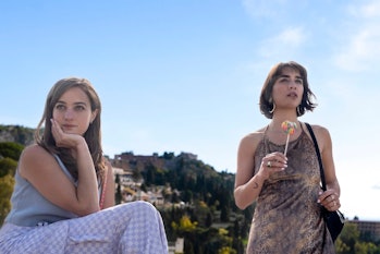 Locals Mia (Beatrice Grannò) and Lucia (Simona Tabasco) watch the new guests arrive.