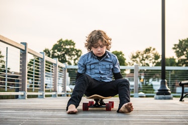 一个没有安全感的孩子坐在滑板上。