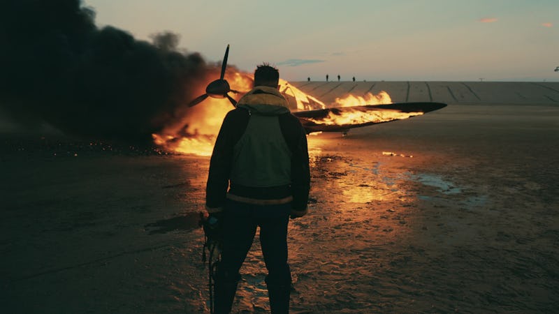 Tom Hardy stands in front of a burning airplane in 2017's Dunkirk