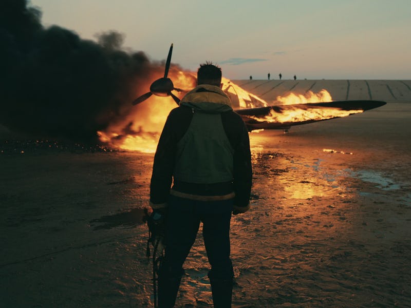 Tom Hardy stands in front of a burning airplane in 2017's Dunkirk