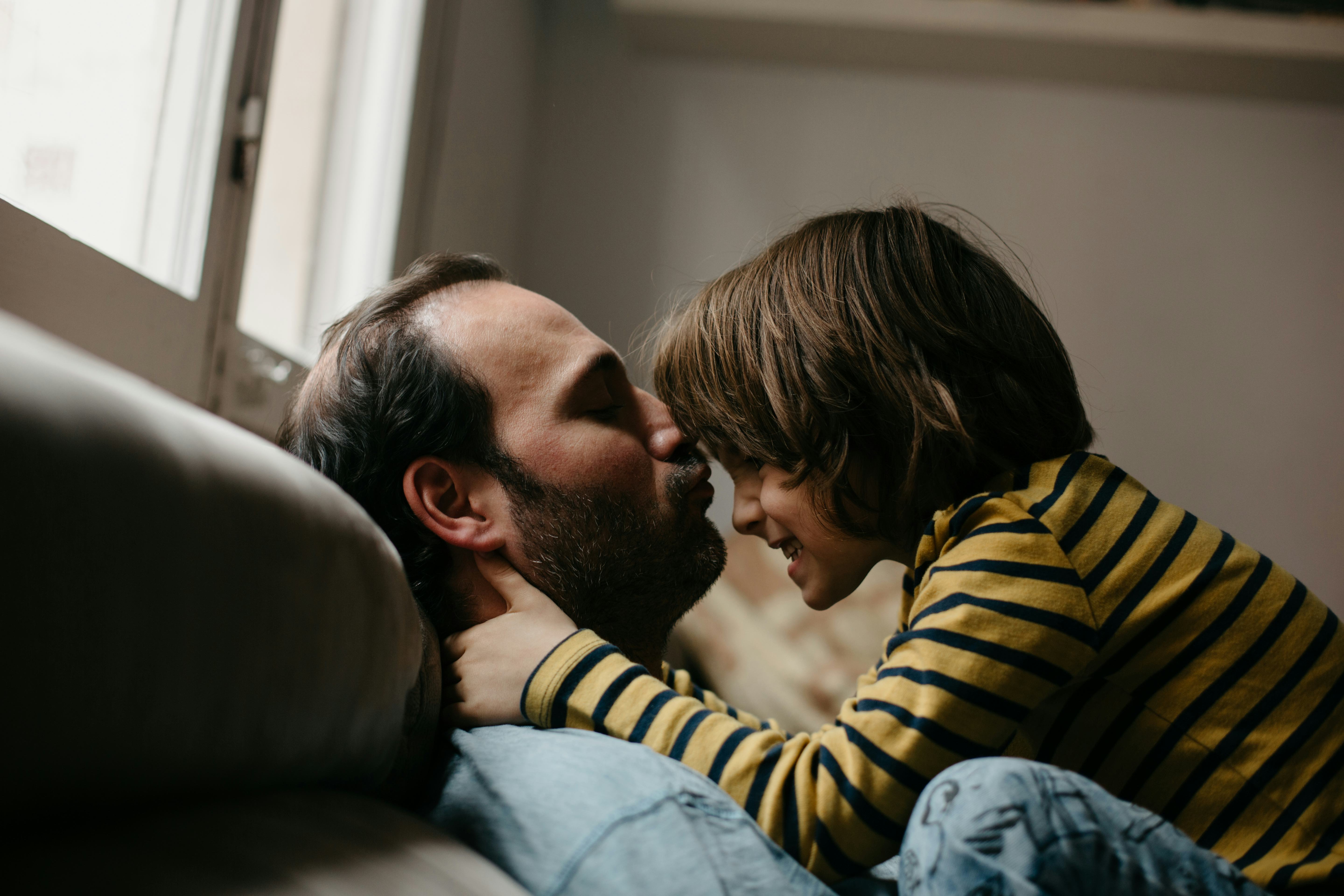 一个孩子和他们的爸爸在沙发上。