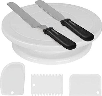 A white cake decorating kit with turntable, two icing spatulas, and three icing smoothers, a good id...
