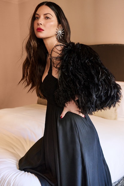 Olivia Munn in a black dress and feathered shrug