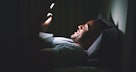 一个男人在床上摸黑发短信。