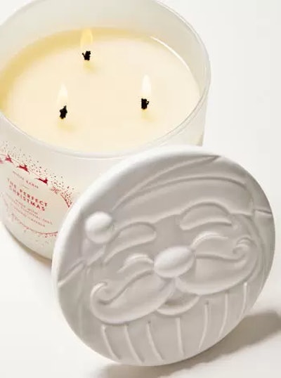 Bath & Body Works Candle Day Sale includes this Christmas candle in a white jar with Santa's face on...