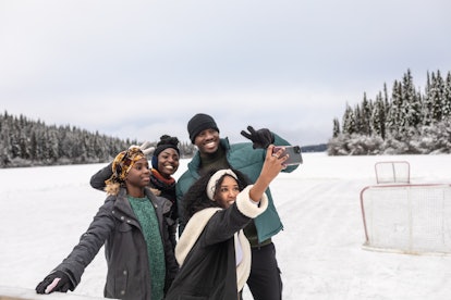 Group of young friends taking a selfie in the snow during the December 2022 full Cold Moon, which wi...
