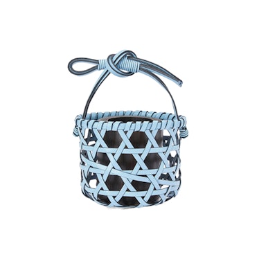 a little woven vase that looks like a basket in blue leather