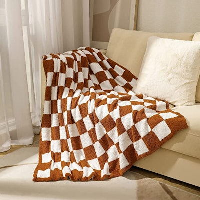 Rust and white checkered throw blanket laying on couch
