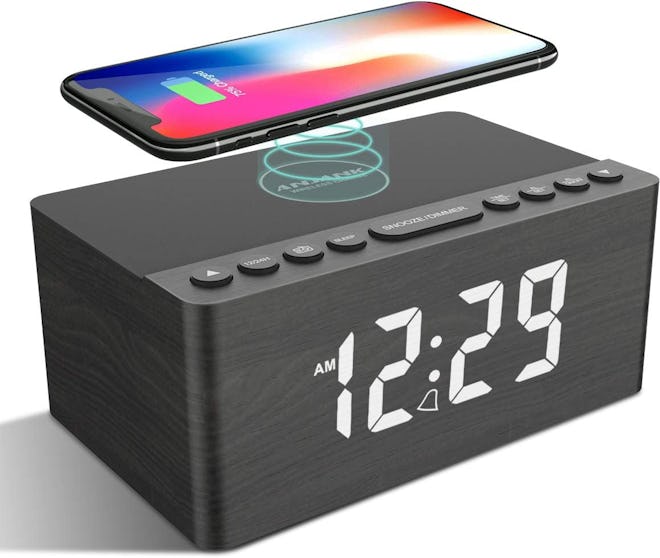 This nightstand charging station and alarm clock wirelessly charges a phone plus any USB-powered dev...