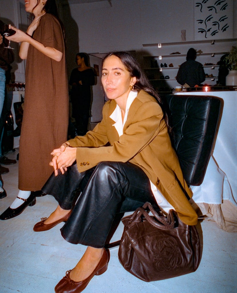 Alexis Badiyi in a brown coat and black pants