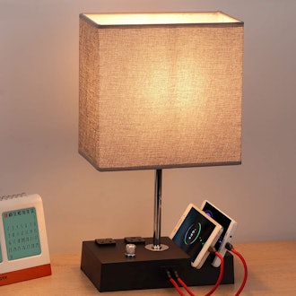 This charging station can fit on a nightstand and features USB ports, AC outlets, and a dimmable lam...