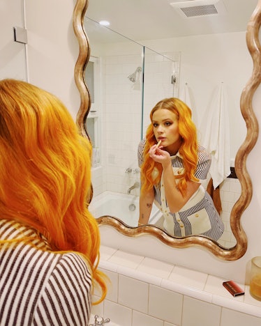 Ava Phillippe puts on lip gloss in mirror