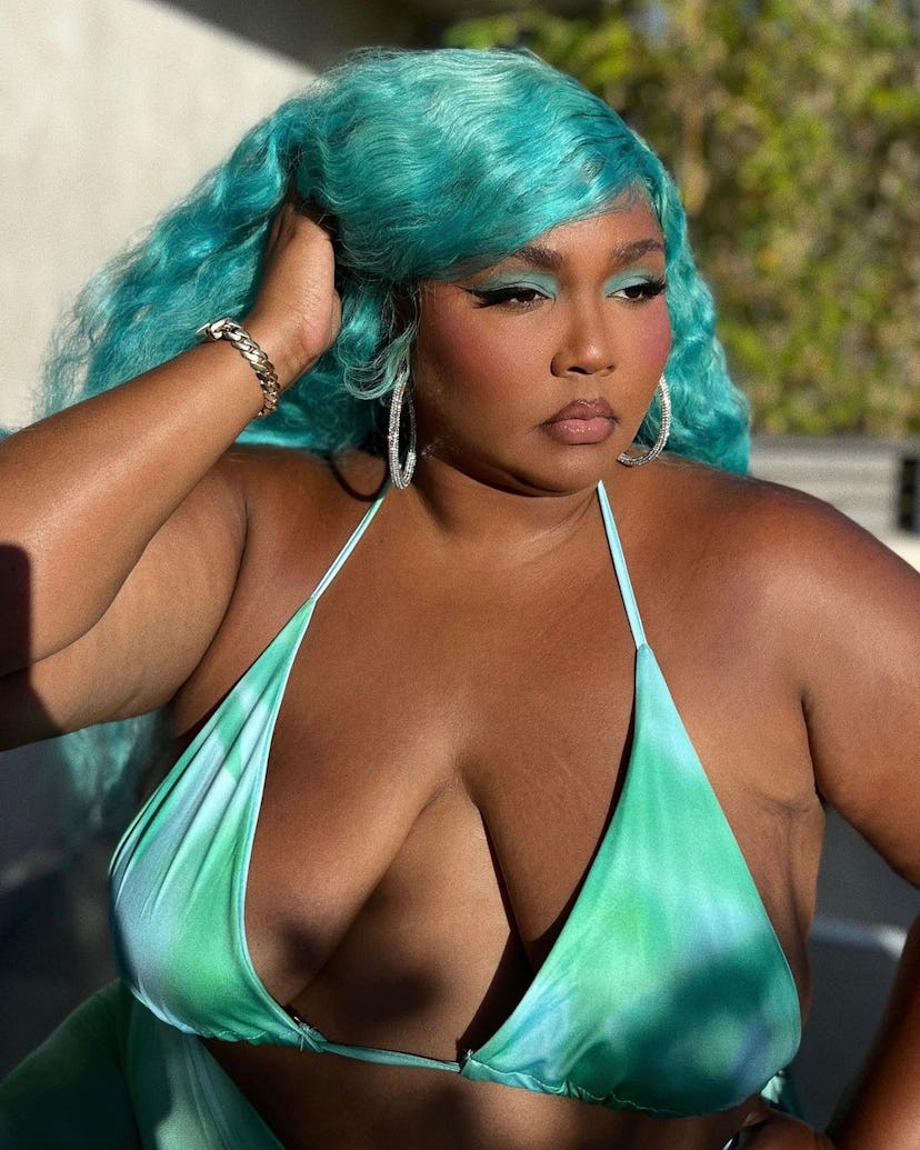 Singer Lizzo in a blue bikini top and turquoise wig.