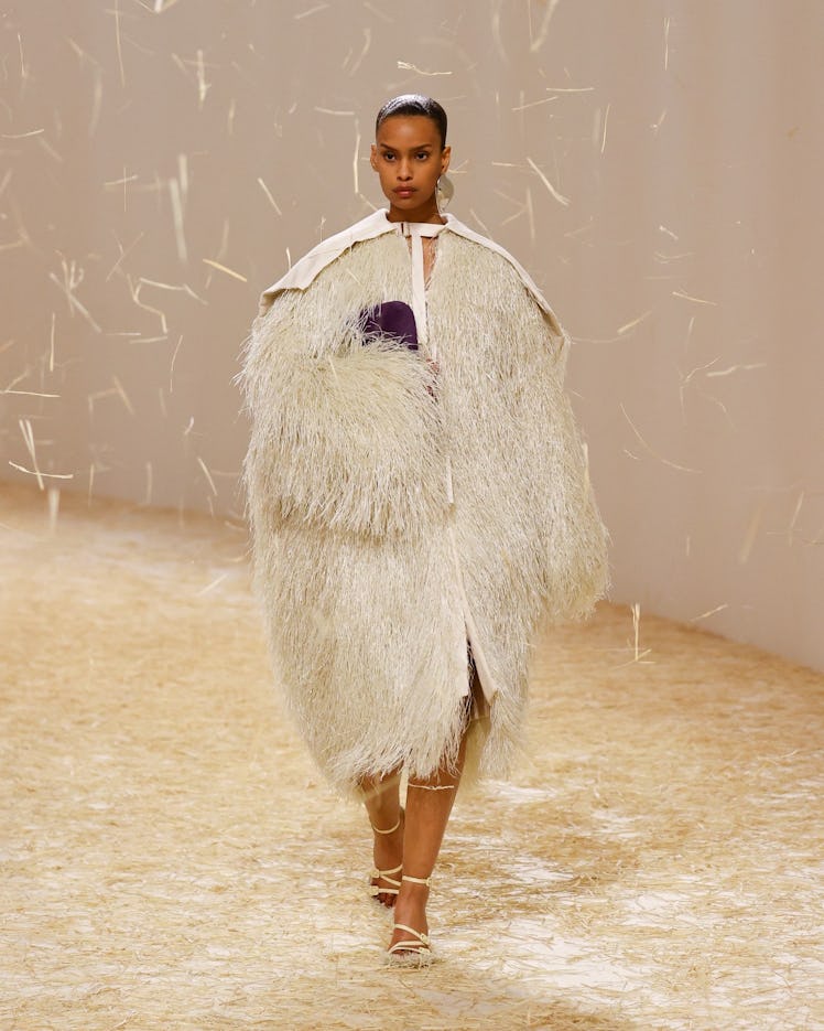 A female model walking in an oversized white fur coat at Jacquemus spring 2023 runway