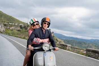 Tanya (Jennifer Coolidge) and Greg (Jon Gries) riding a vespa together in The White Lotus Season 2