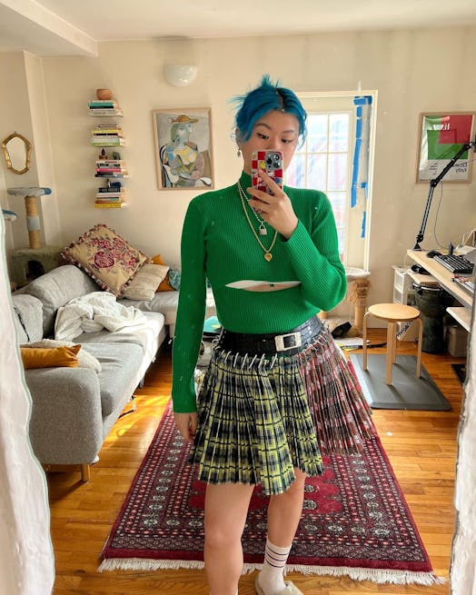 Mi-Anne wearing a green sweater and skirt