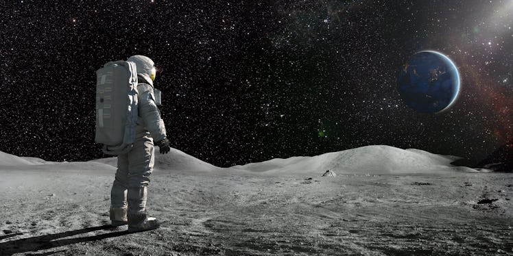 Astronaut on the moon looking at a distant Earth