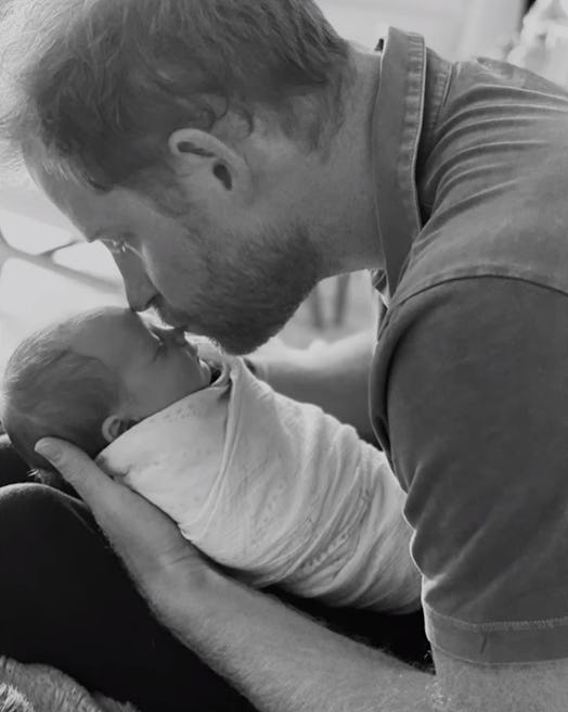 Prince Harry kisses an infant Lilibet.
