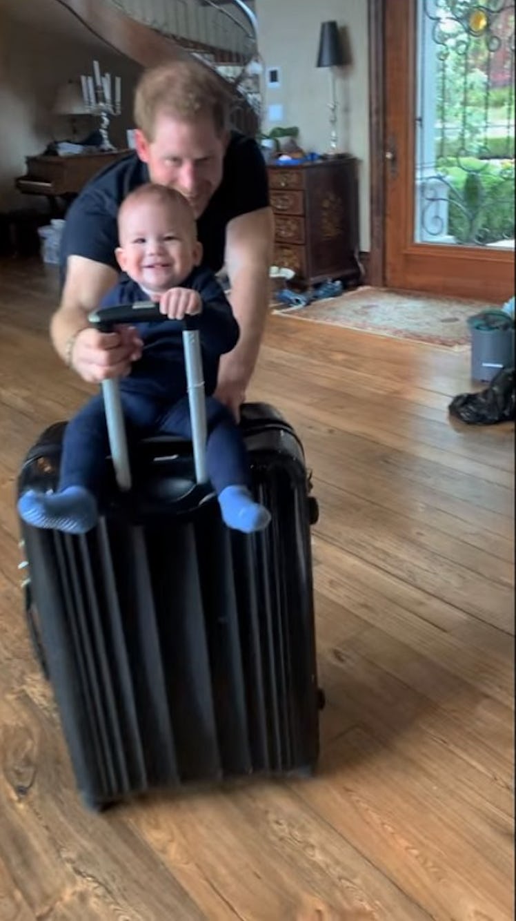 Archie riding his father's suitcase.