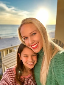 A mom and her daughter smile in a selfie with a beach scene in the background. Taken using iPhone ph...