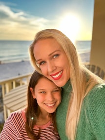 Eine Mutter und ihre Tochter lächeln in einem Selfie mit einem Strand im Hintergrund.  Aufgenommen mit dem iPhone ph...
