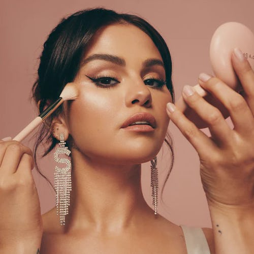Selena Gomez poses with the Positive Light Silky Touch Highlighter in one hand and a highlighter bru…