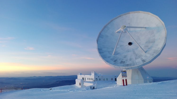 radio telescope on a snowy mountain side