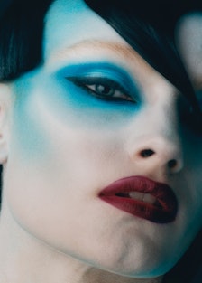 A model with a red lip and blue eyeshadow