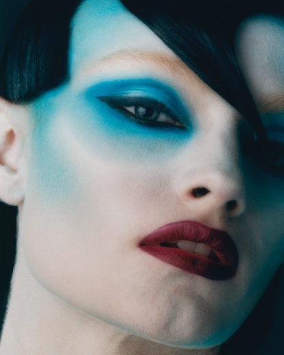 A model with a red lip and blue eyeshadow