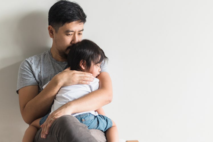 A dad holds his sick toddler.