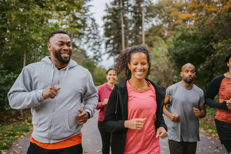 A sweaty man and woman on a jog outdoors.