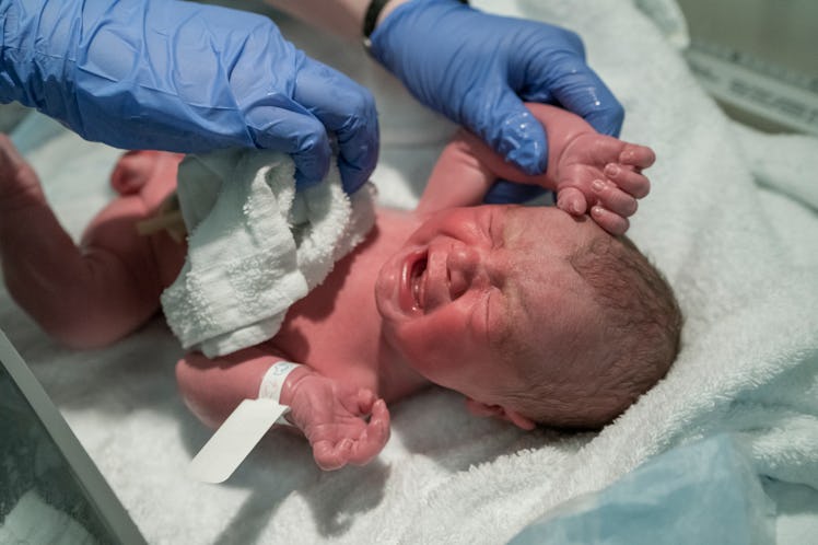 A newborn baby getting a bath in a hospital.