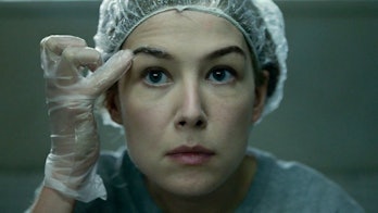 Amy stares straight ahead -- she's looking in a mirror -- wearing a plastic cap and gloves as she co...