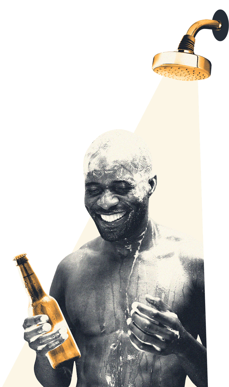 A man taking a shower while holding a beer.