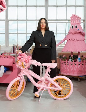 Artist Yvette Mayorga standing amongst her candy-pink creations