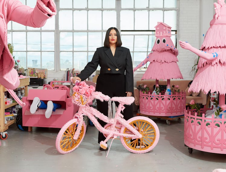 Artist Yvette Mayorga standing amongst her candy-pink creations