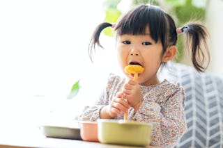 A little girl eats chicken nuggets, which can be a great at-home hack for when your kids crave fast ...