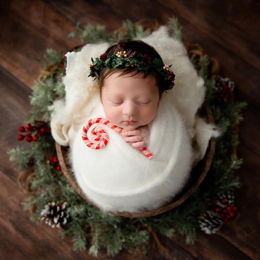 baby swaddled in blanket and in basket with candy cane for a holiday baby announcement 