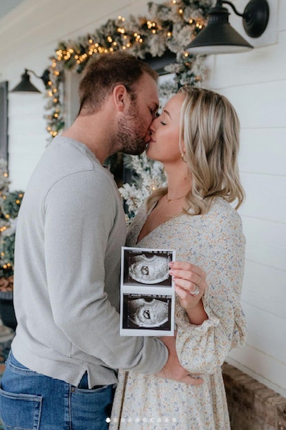 photo of couple kissing holding a sonogram photo for a Christmas baby announcement