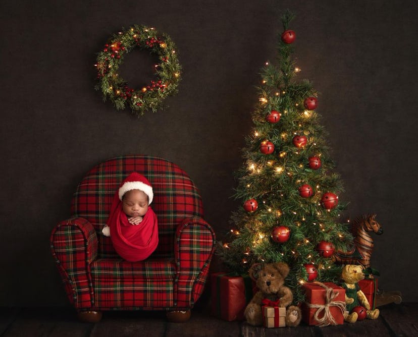 baby sleeping on chair next to Christmas tree as part for a Christmas baby announcement 