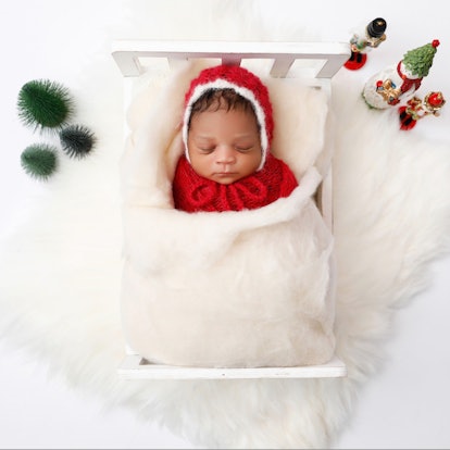 baby sleeping in bed for a holiday baby announcement 
