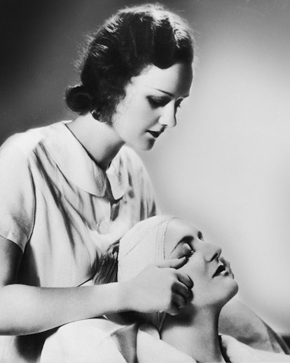A woman receiving a facial treatment from an aesthetician