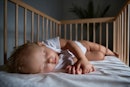一个婴儿睡在一个床上。
