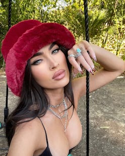 Megan Fox weairing a red fuzzy hat.