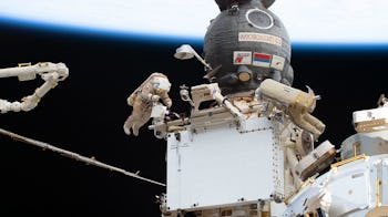 The top of the image is the blue of planet Earth. The Russian crew capsule Soyuz MS-22 sticks out in...