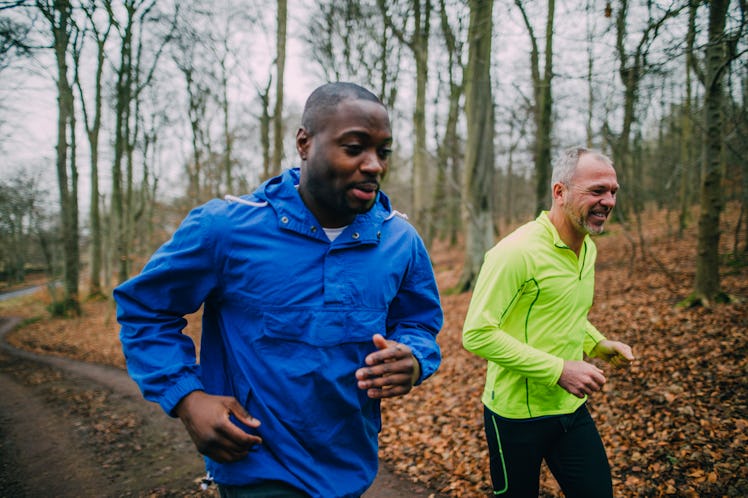 Two men running in the woods.