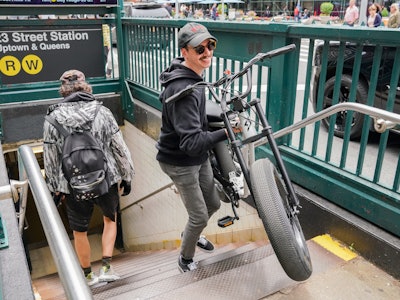 Inverse editor James Pero lifting a Super73 e-bike up stairs