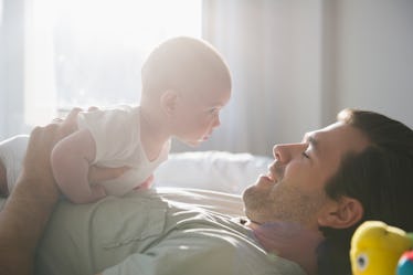 Man looking into infant's eyes as he holds him to his chest