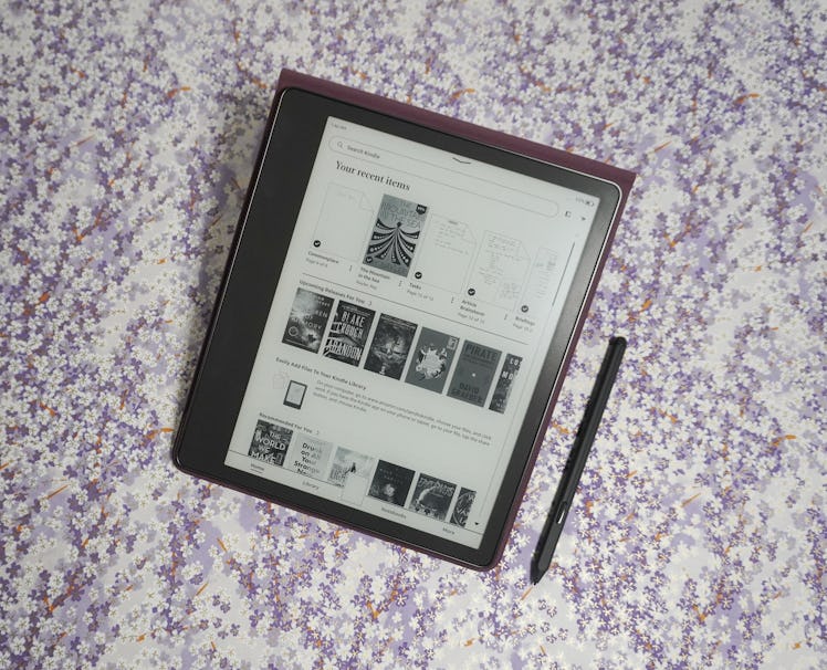 The Kindle Scribe propped up in its case with its pen on the side.