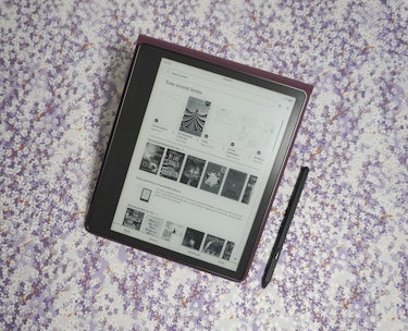 The Kindle Scribe propped up in its case with its pen on the side.